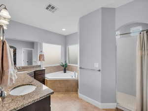 Bathroom with tile patterned flooring, vanity, separate shower and tub, and a healthy amount of sunlight