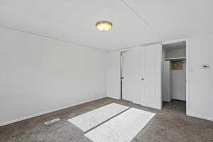 Unfurnished bedroom with a closet and carpet floors