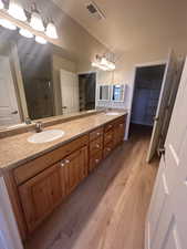 Bathroom featuring vanity, an enclosed shower, and hardwood / wood-style flooring