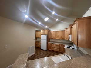 Kitchen featuring white appliances, high vaulted ceiling, and sink