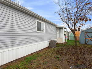 View of property exterior featuring a storage unit and central air condition unit