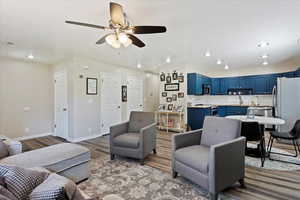 Living room with wood-type flooring, ceiling fan, and sink