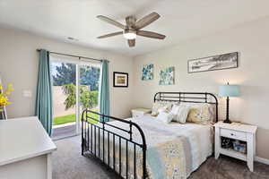 Bedroom featuring access to exterior, ceiling fan, and dark colored carpet