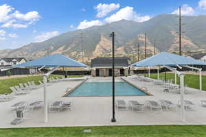 View of swimming pool with a gazebo, a mountain view, and a patio area