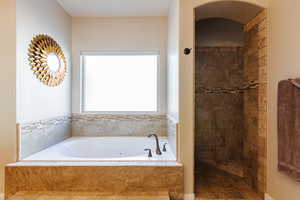 Bathroom featuring shower with separate bathtub