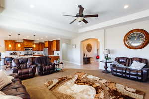 Living room with ceiling fan and light carpet