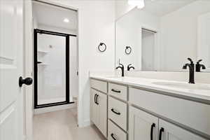 Bathroom featuring tile patterned floors, vanity, a shower with shower door, and toilet