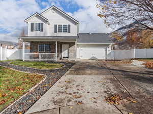 View of front property featuring a porch, a garage, and a front yard