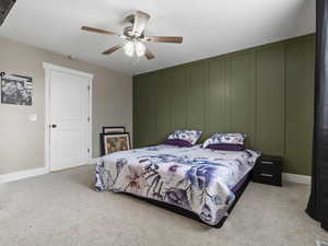 Carpeted bedroom featuring ceiling fan