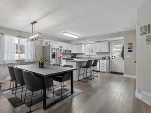 Dining room featuring light wood-type flooring, a textured ceiling, and sink