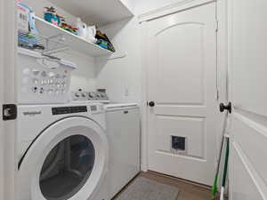 Laundry room with wood-type flooring and washing machine and clothes dryer