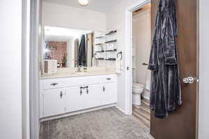 Bathroom featuring vanity, wood-type flooring, and toilet