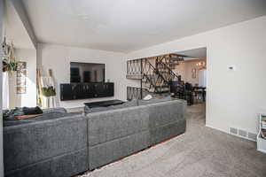 Carpeted living room featuring an inviting chandelier