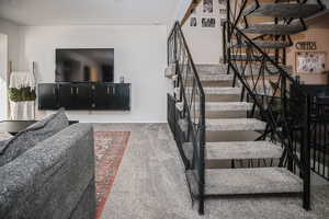 Staircase featuring carpet flooring