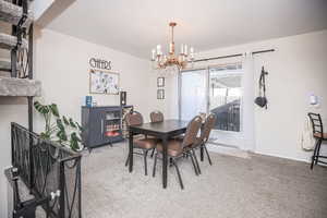 Dining area with carpet floors and a chandelier