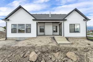 Back of property featuring a patio and roof with shingles