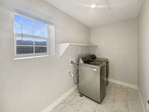 Laundry area with a mountain view and independent washer and dryer