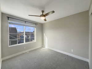 Carpeted empty room with ceiling fan