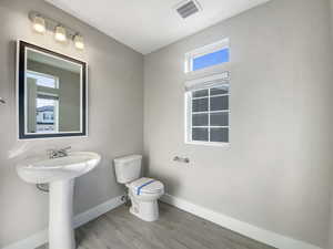 Bathroom featuring hardwood / wood-style flooring and toilet