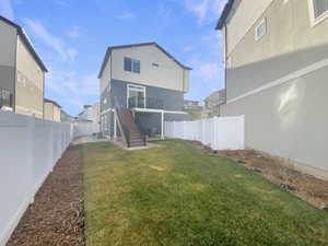 Rear view of house with a yard and a deck