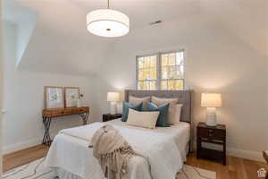 Bedroom featuring light wood-type flooring and lofted ceiling