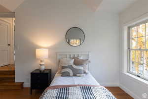 Bedroom featuring wood-type flooring and lofted ceiling