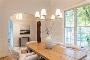 Dining area featuring wood-type flooring and an inviting chandelier