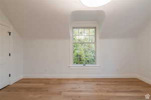 Bonus room featuring light wood-type flooring and lofted ceiling