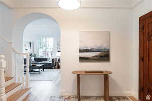 Foyer featuring light wood-type flooring and crown molding