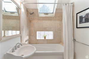 Bathroom featuring shower / bath combo with shower curtain and sink