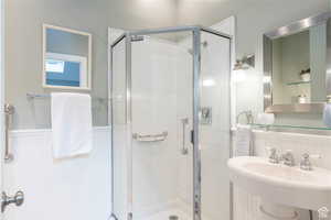 Bathroom with a shower with shower door and sink