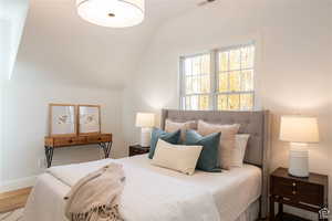 Bedroom featuring wood-type flooring and lofted ceiling