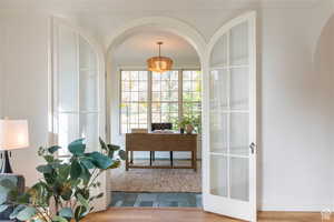 Office with wood-type flooring and french doors