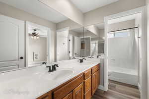 Full bathroom with vanity, ceiling fan, wood-type flooring, shower / tub combination, and toilet