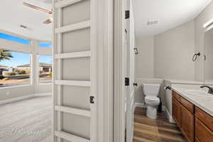 Bathroom with hardwood / wood-style floors, vanity, and toilet