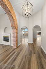 Interior space featuring dark wood-type flooring, a high ceiling, and an inviting chandelier