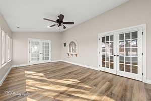 Unfurnished room featuring ceiling fan, french doors, hardwood / wood-style floors, and vaulted ceiling