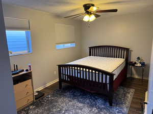 Bedroom with ceiling fan, dark hardwood / wood-style flooring, and a textured ceiling