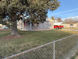 Exterior space featuring a mountain view, a front lawn, and a carport