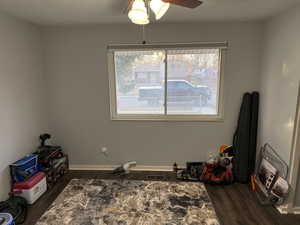 Misc room featuring dark hardwood / wood-style floors, ceiling fan, and a textured ceiling