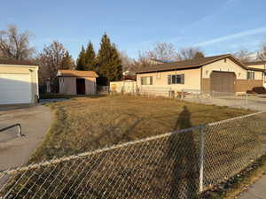 Single story home with a front yard and a storage shed