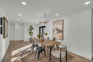 Dining area with light wood-type flooring and a notable chandelier