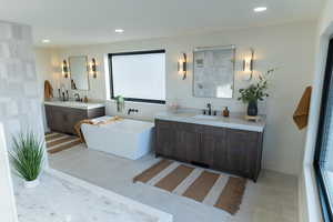 Bathroom with a bathtub, vanity, and tile patterned flooring