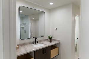 Bathroom featuring a tile shower, vanity, and toilet