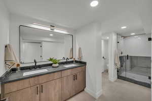 Bathroom featuring vanity, toilet, and an enclosed shower