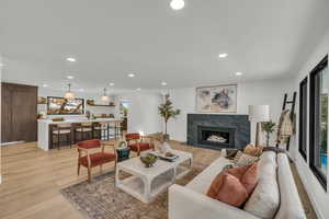 Living room featuring light wood-type flooring and a high end fireplace