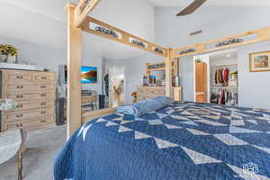 Carpeted bedroom with ceiling fan and a closet