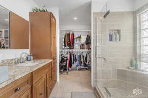 Bathroom with tile patterned floors, vanity, a shower with shower door, and a textured ceiling