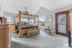 Bedroom featuring carpet and vaulted ceiling