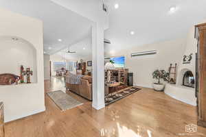 Living room featuring a wealth of natural light, vaulted ceiling, and light wood-type flooring